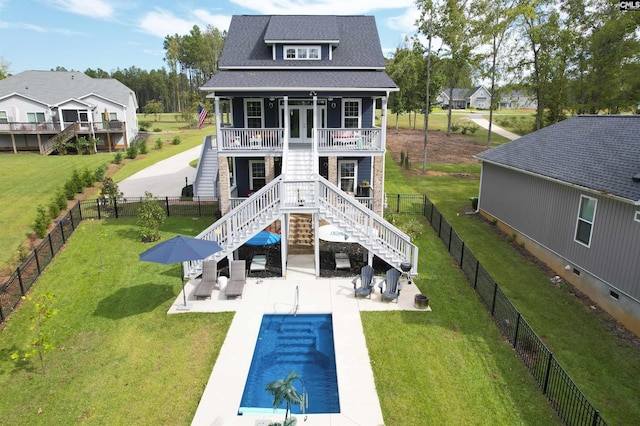 back of property with french doors, stairway, a fenced backyard, and a lawn