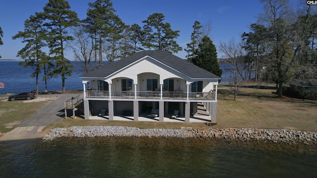 back of property featuring a water view, a patio area, and stairs