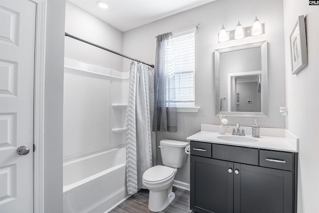 full bathroom featuring wood finished floors, shower / bath combo, vanity, and toilet