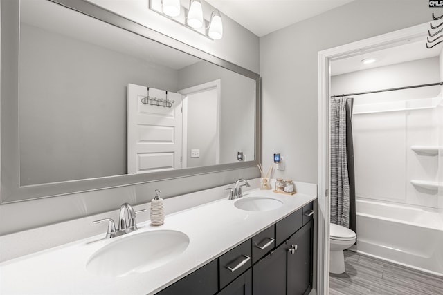 bathroom featuring shower / bath combination with curtain, a sink, toilet, and double vanity