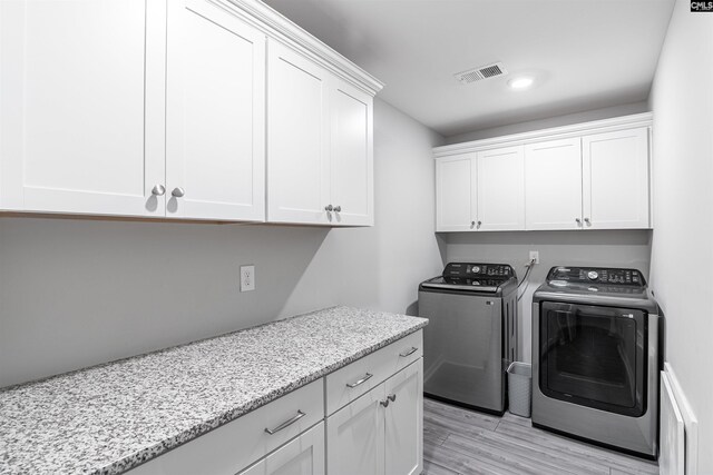 laundry area with cabinet space, visible vents, washer and clothes dryer, light wood-style flooring, and recessed lighting