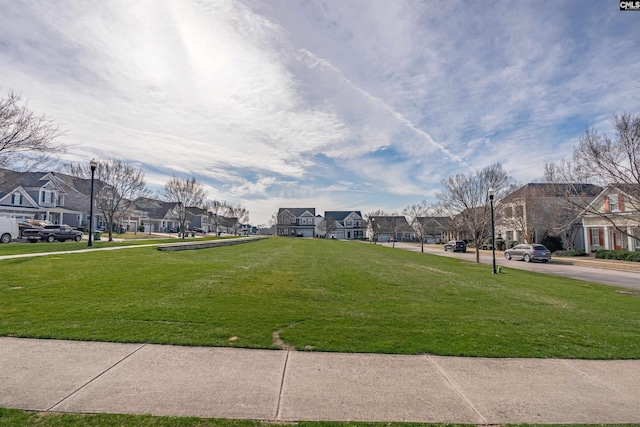 view of home's community with a residential view and a lawn