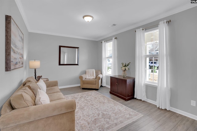 living area featuring light wood-style flooring, visible vents, and ornamental molding