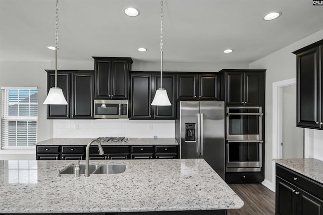 kitchen featuring dark cabinets, stainless steel appliances, and a sink