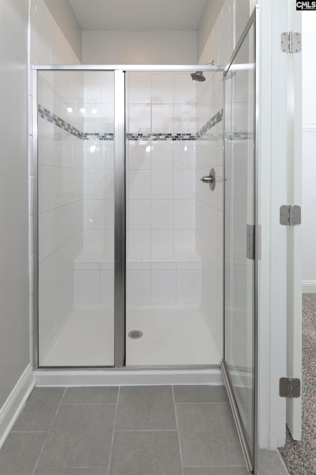 full bathroom featuring a stall shower and tile patterned flooring