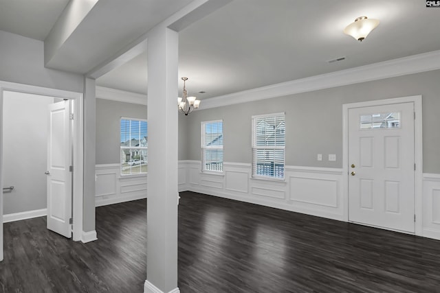 entryway featuring visible vents, a wainscoted wall, dark wood-type flooring, crown molding, and a notable chandelier