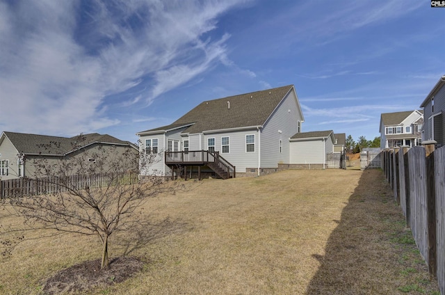 rear view of property with a fenced backyard, a lawn, and a wooden deck