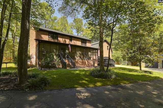 view of front of house featuring a front lawn and brick siding