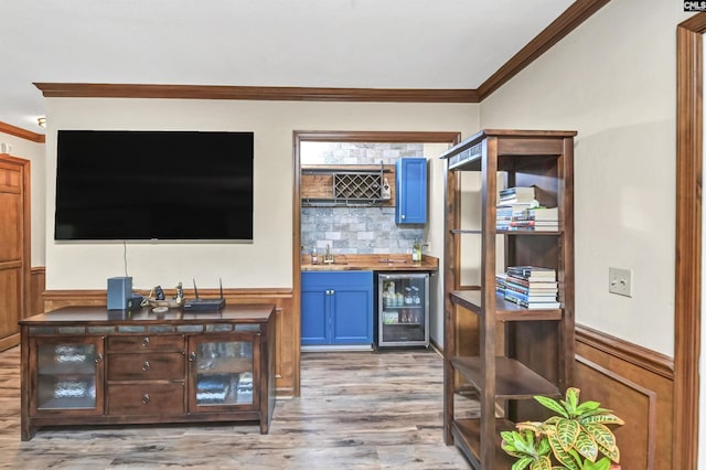 bar with a wainscoted wall, wine cooler, and indoor wet bar