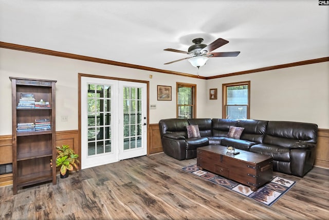 living area featuring a wainscoted wall, wood finished floors, and a healthy amount of sunlight