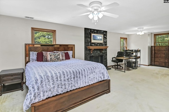 bedroom with carpet, a fireplace, visible vents, ceiling fan, and baseboards