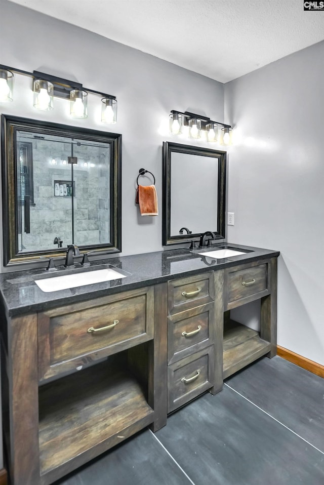 full bathroom featuring a sink, baseboards, and double vanity