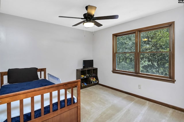 bedroom with light carpet, ceiling fan, and baseboards