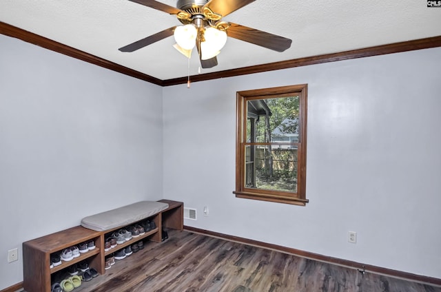 spare room featuring a textured ceiling, wood finished floors, visible vents, baseboards, and ornamental molding