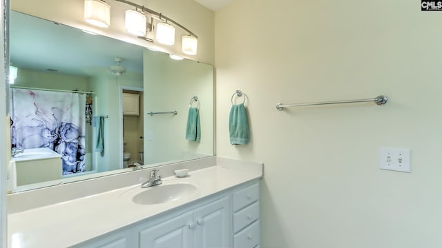 full bath featuring toilet, vanity, and a shower with shower curtain