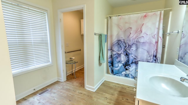 bathroom featuring a shower with curtain, visible vents, baseboards, wood finished floors, and vanity