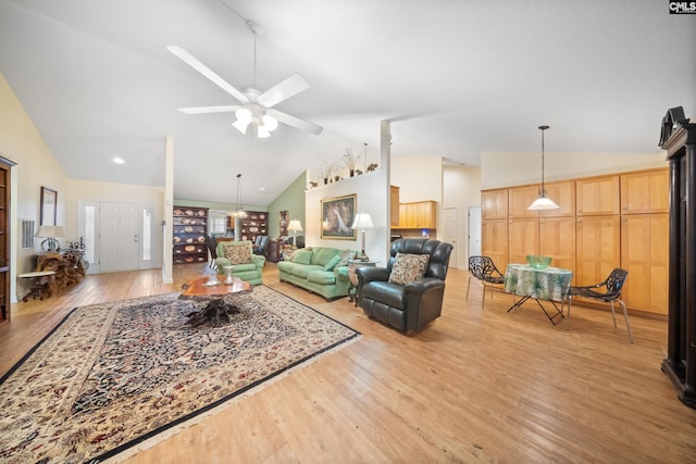 living room with light wood-type flooring, ceiling fan, and high vaulted ceiling