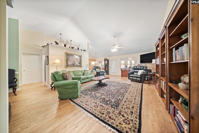 living area featuring high vaulted ceiling, a ceiling fan, and wood finished floors