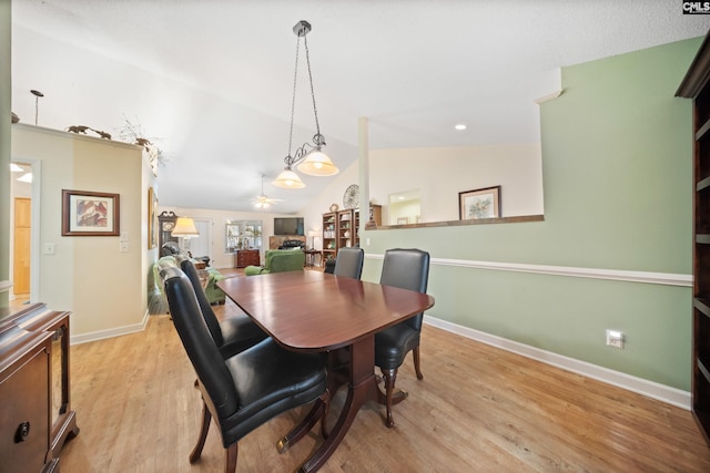 dining room with light wood-type flooring, vaulted ceiling, baseboards, and ceiling fan