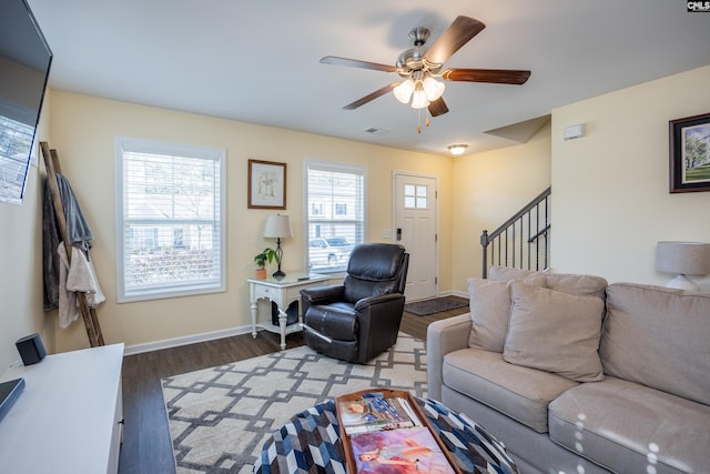 living area featuring visible vents, stairway, ceiling fan, wood finished floors, and baseboards