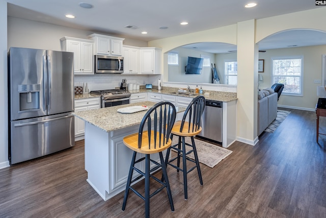 kitchen with appliances with stainless steel finishes, dark wood-style flooring, a sink, and visible vents