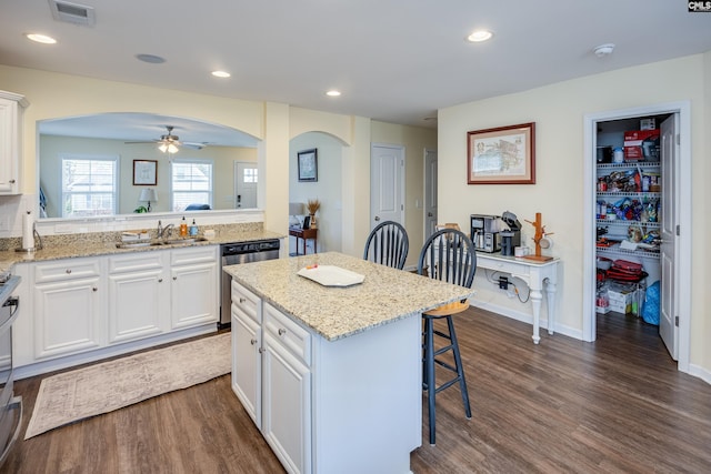 kitchen with arched walkways, stainless steel appliances, a breakfast bar area, and visible vents