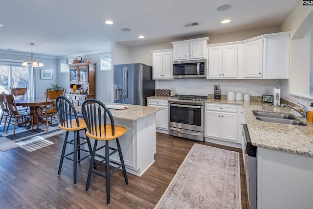 kitchen featuring appliances with stainless steel finishes, visible vents, a sink, and white cabinetry