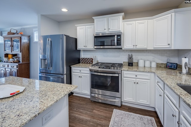 kitchen featuring decorative backsplash, white cabinetry, stainless steel appliances, and dark wood-type flooring