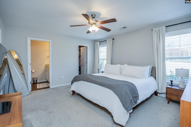 bedroom with visible vents, a spacious closet, a ceiling fan, carpet flooring, and baseboards