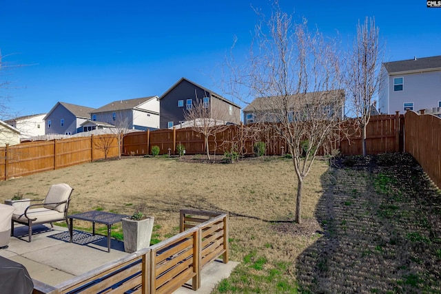 view of yard with a residential view, a fenced backyard, and a patio