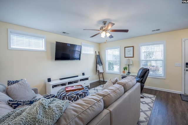 living room featuring dark wood-style floors, a ceiling fan, visible vents, and baseboards