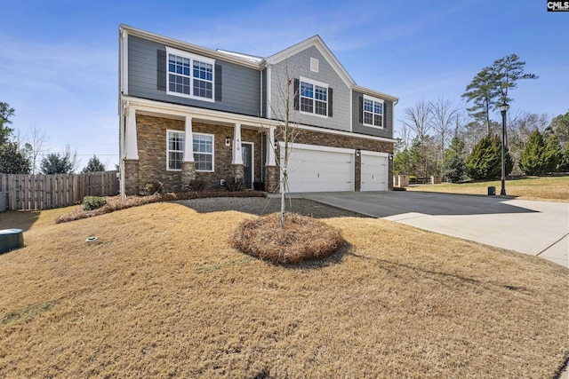 view of front of property featuring a garage, stone siding, fence, and concrete driveway