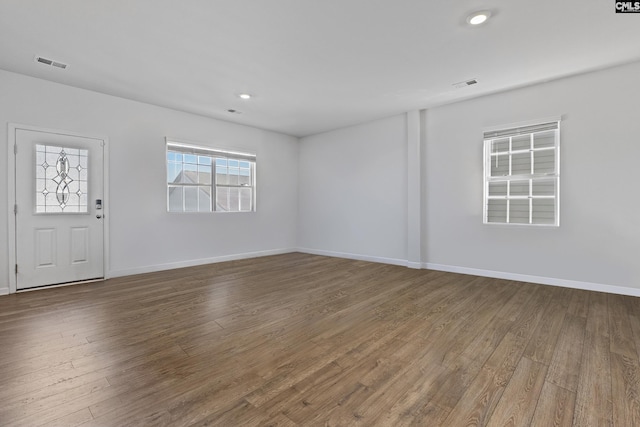 unfurnished room with visible vents, baseboards, and wood finished floors