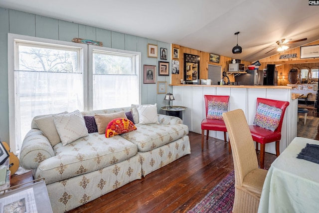 living area featuring vaulted ceiling, hardwood / wood-style flooring, and a ceiling fan