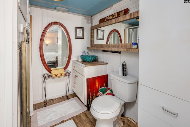 ensuite bathroom featuring toilet, wood finished floors, and ensuite bathroom