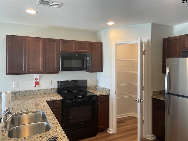 kitchen with recessed lighting, visible vents, a sink, wood finished floors, and black appliances