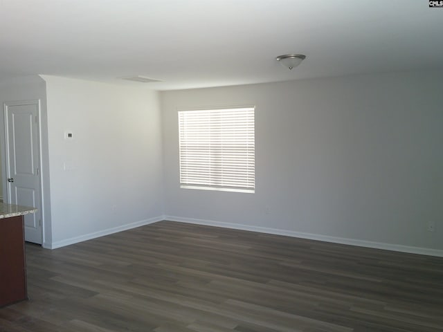 unfurnished room with dark wood-style floors and baseboards