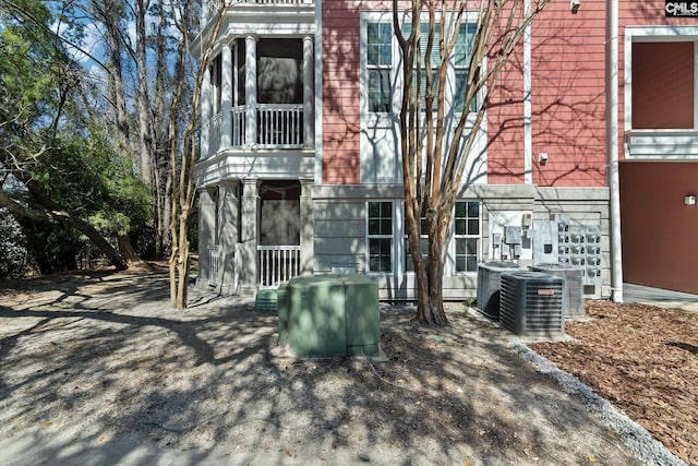 view of front of house featuring a balcony and central air condition unit