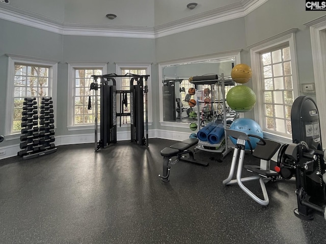 workout area featuring ornamental molding, plenty of natural light, and baseboards