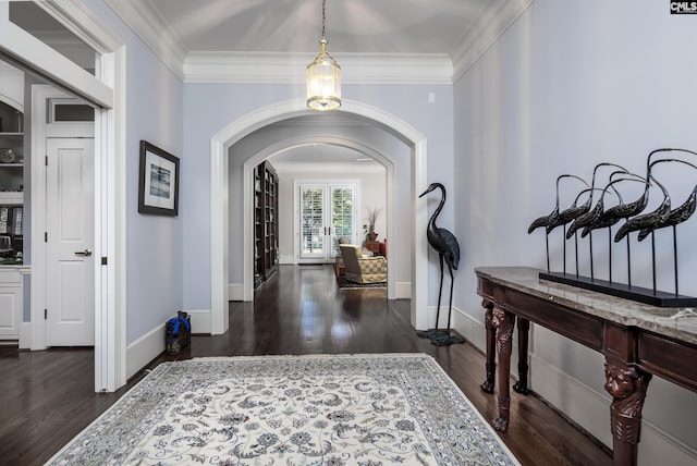 entrance foyer featuring arched walkways, french doors, dark wood-style flooring, and crown molding