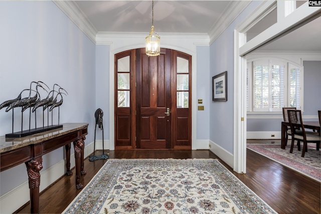 foyer entrance with dark wood-style floors, arched walkways, and crown molding