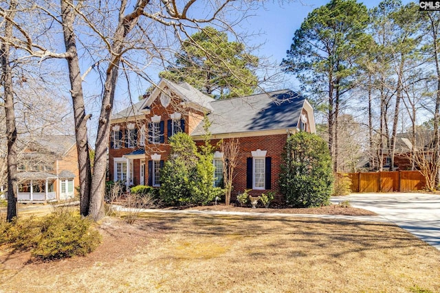 view of front of property with brick siding and fence