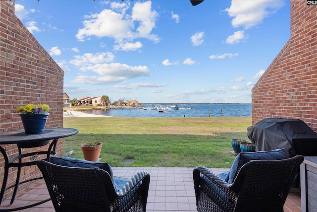 view of patio / terrace featuring a water view, a grill, and an outdoor living space