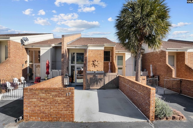 view of front of home featuring a fenced front yard, a gate, and brick siding