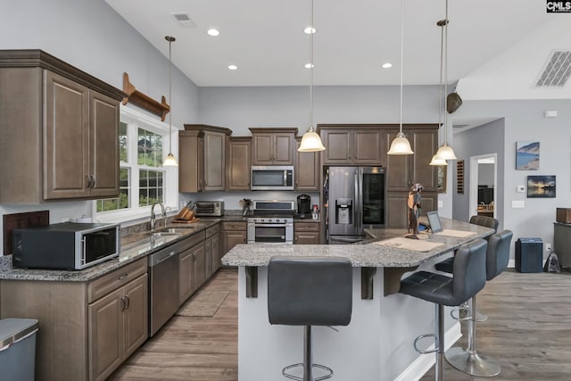 kitchen with light wood finished floors, visible vents, appliances with stainless steel finishes, and a sink