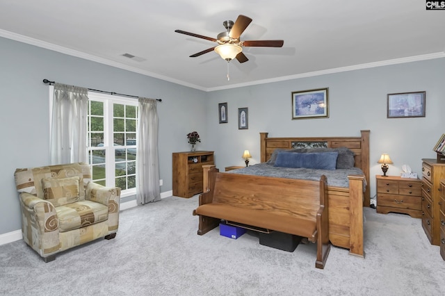 carpeted bedroom featuring baseboards, a ceiling fan, visible vents, and crown molding