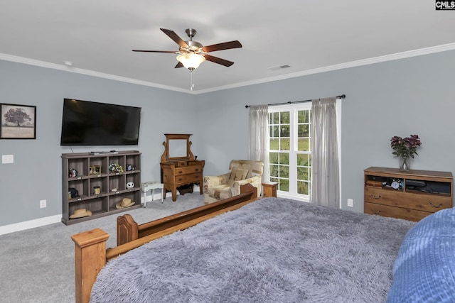 carpeted bedroom featuring baseboards, ceiling fan, visible vents, and crown molding