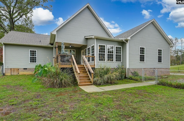 rear view of house featuring a yard, a gate, fence, a wooden deck, and stairs