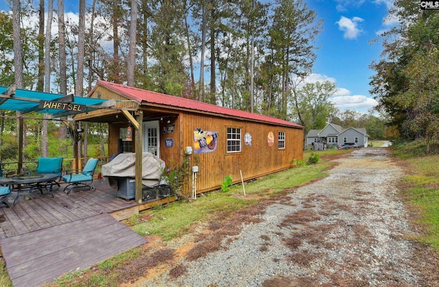 view of side of home with a deck and metal roof