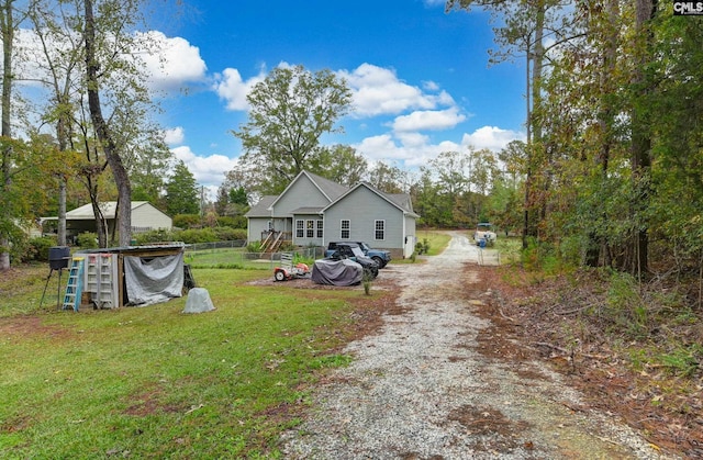 back of property featuring driveway and a lawn